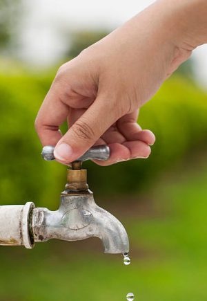 Woman hand shut the faucet, prevent from leaking waste